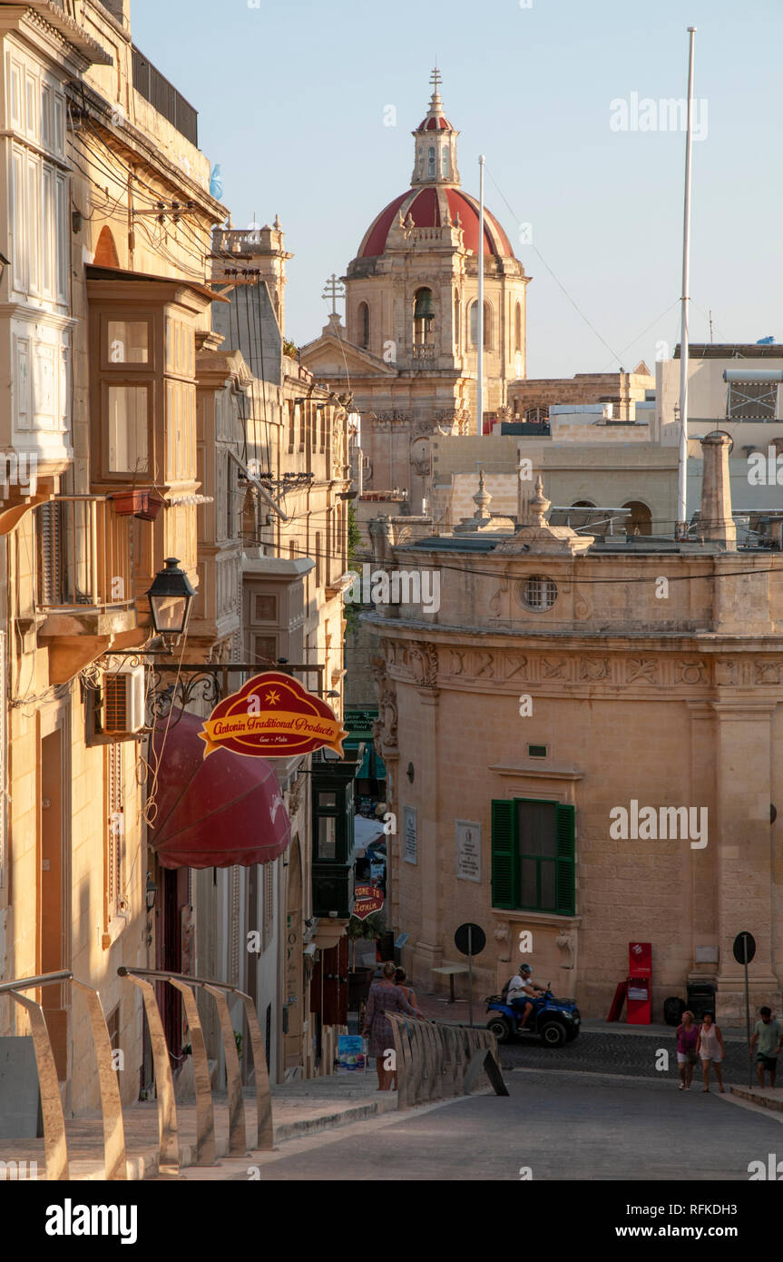 Guardando verso il basso It-Telgha tal-nastro Street di fronte alla Cittadella con la Basilica di San Giorgio in background e Victoria consiglio locale di fronte. Foto Stock