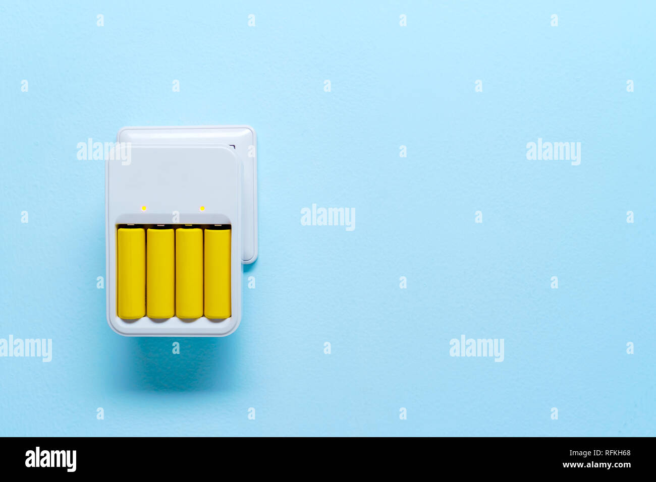 Immagine di un caricabatterie con batterie di colore giallo Foto Stock
