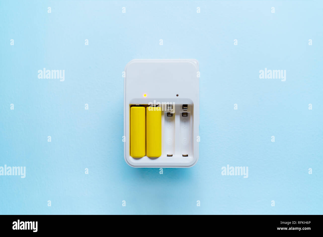 Immagine di un caricabatterie con batterie di colore giallo Foto Stock