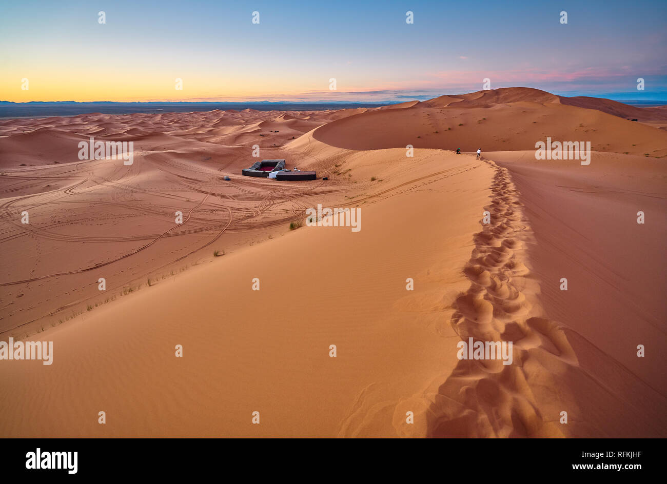 Passi e campo berbero nel deserto all'alba. La foto del paesaggio desertico è stata scattata a Erg Chebbi vicino a Merzouga, Marocco sahariano. Foto Stock