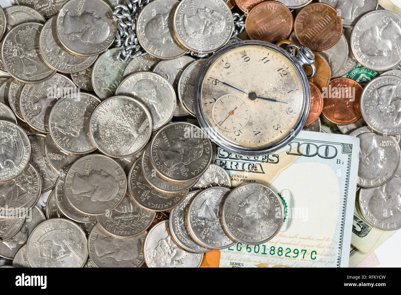 Tempo e denaro concetto Close up di un denaro e un vecchio orologio da tasca Foto Stock