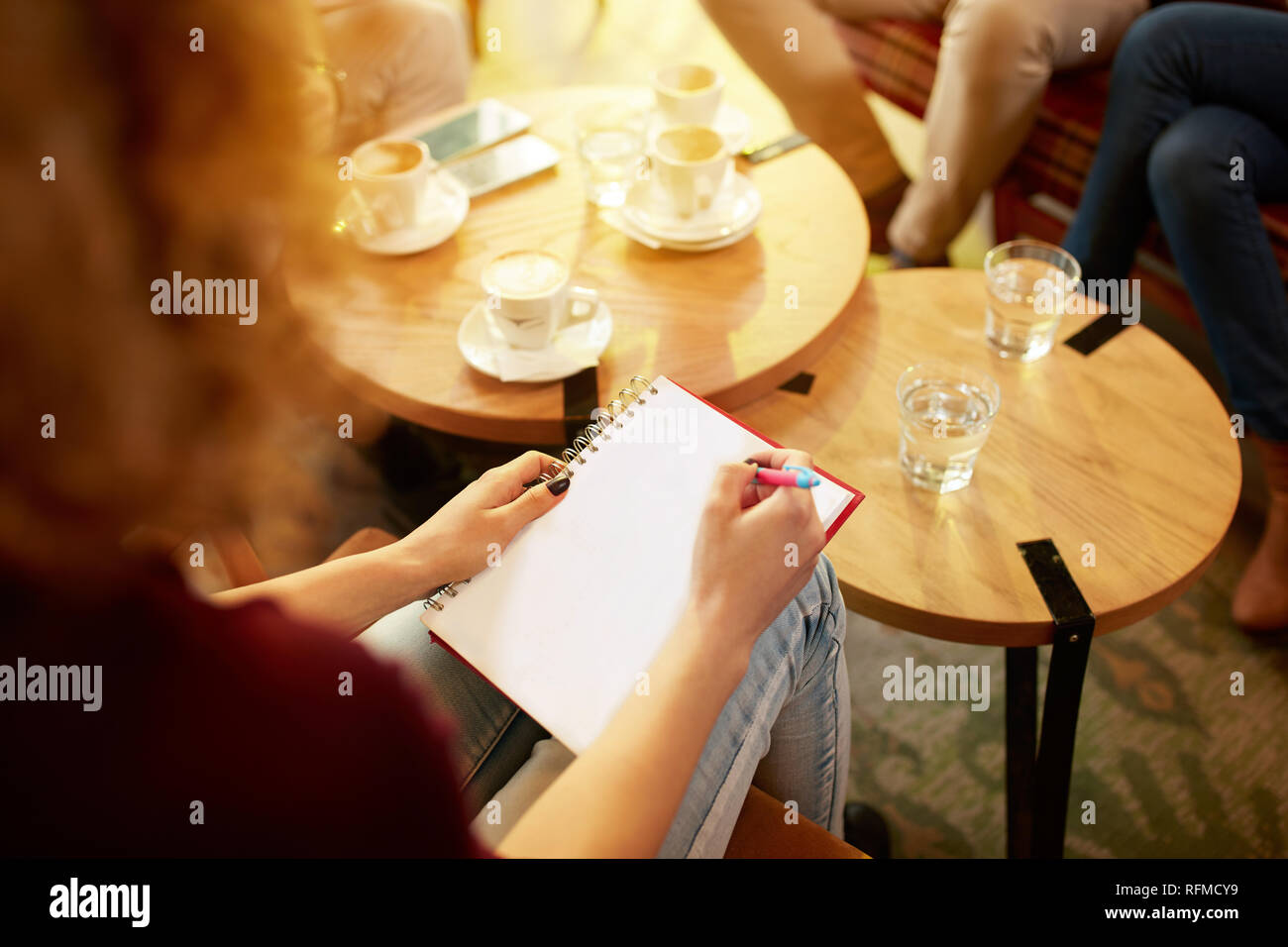 Close up della donna la scrittura a mano in studente cafe Foto Stock