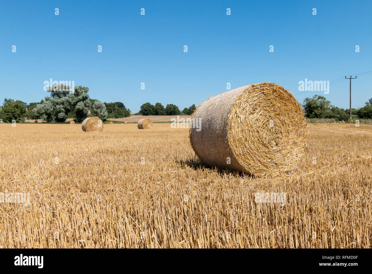 Round balle di fieno in un campo vicino alla chiesa di Tutti i Santi, Aldwincle, Northamptonshire Foto Stock