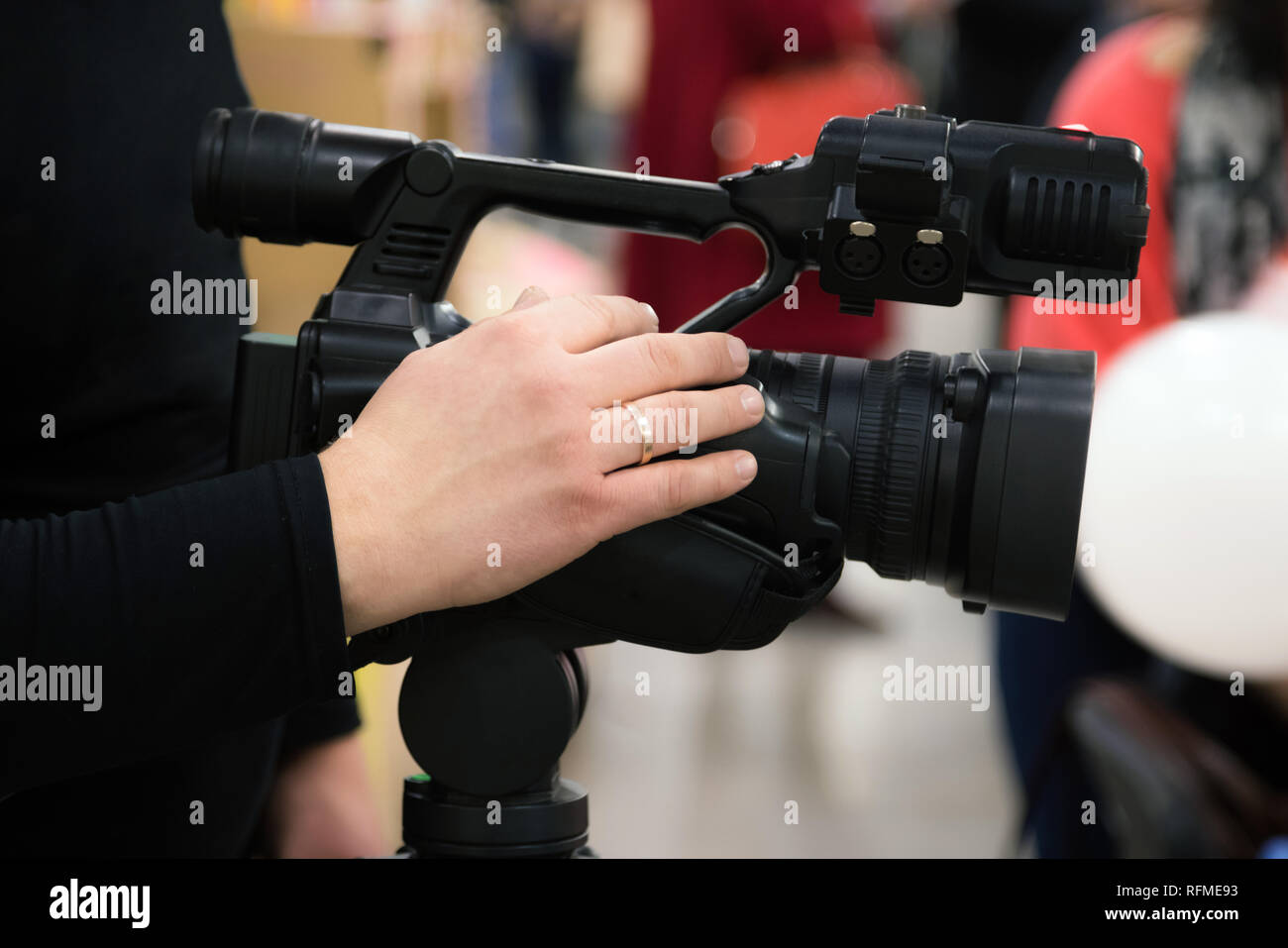 Copertura di un evento con una videocamera. Videografo film con la telecamera video. Fotocamera operatore che lavora in ambienti interni Foto Stock