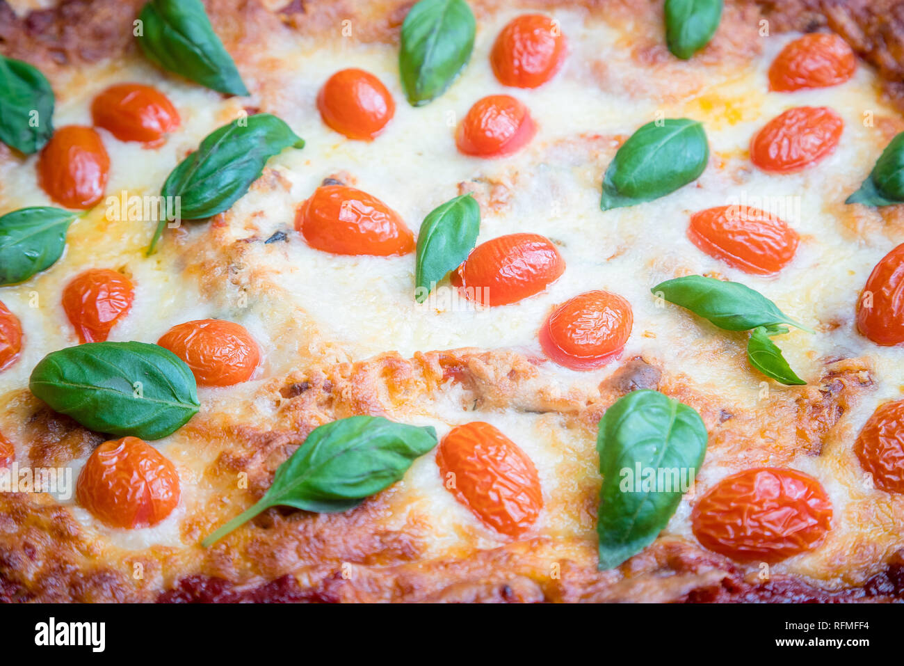 Close up appena eseguito Lasagne Vegetariane decorate con pomodoro, formaggio ed erbe aromatiche Foto Stock