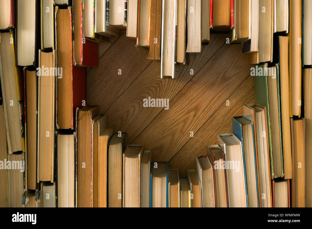 Il concetto di amore del cuore forma dal vecchio vintage libri su pavimento in legno sfondo. Colore vintage stile tono di composizione di amore con il libro aperto cuore Foto Stock