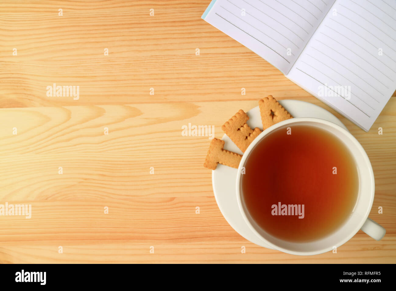 Vista dall'alto di una tazza di tè caldo e la parola tè fatto dai cookie, con una nota di foderato le carte sul tavolo in legno Foto Stock