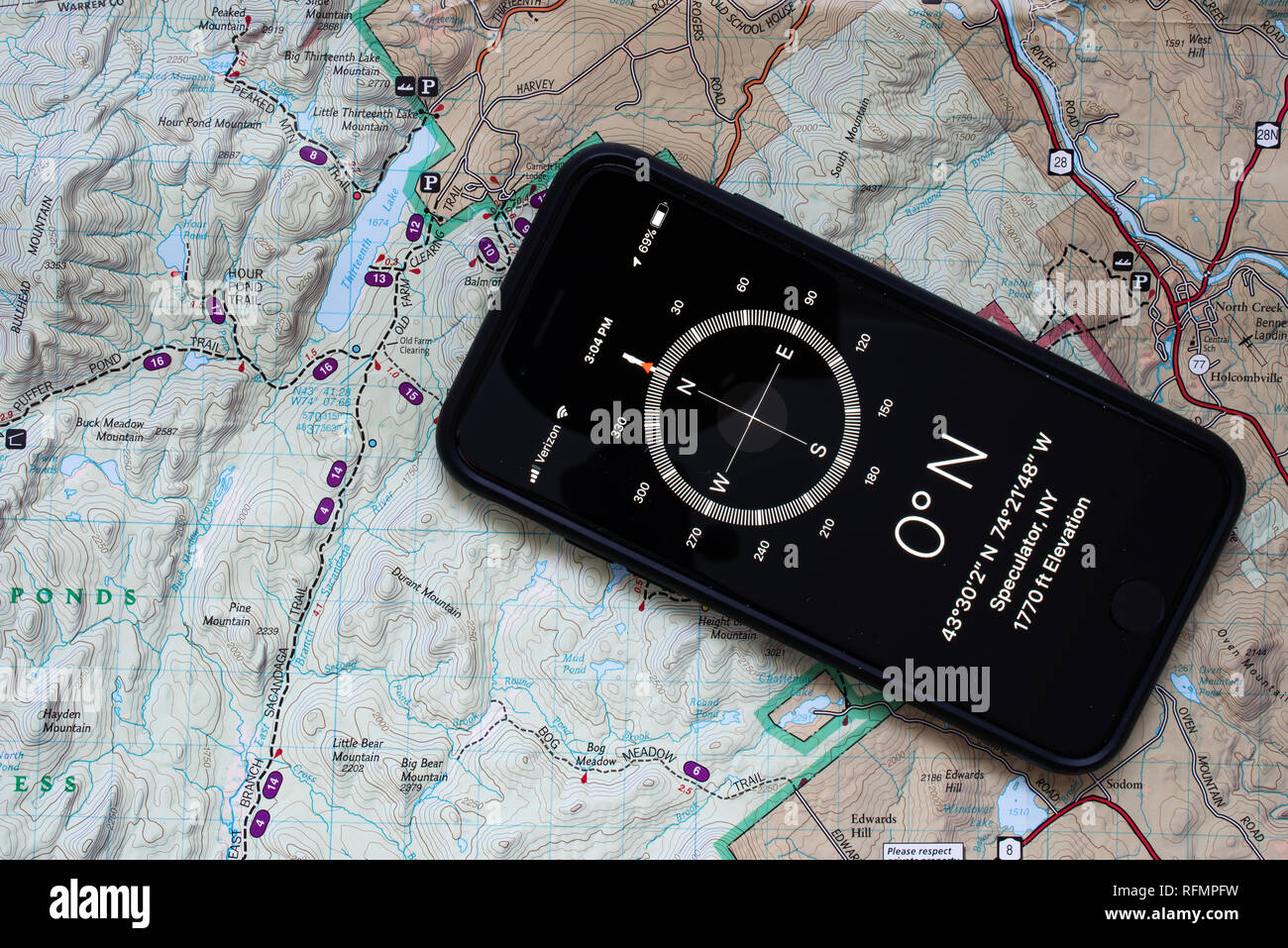 Un iPhone 7 con un'applicazione bussola mostrata con una carta topografica  di una porzione delle Montagne Adirondack, per facilitare la navigazione  nel deserto Foto stock - Alamy