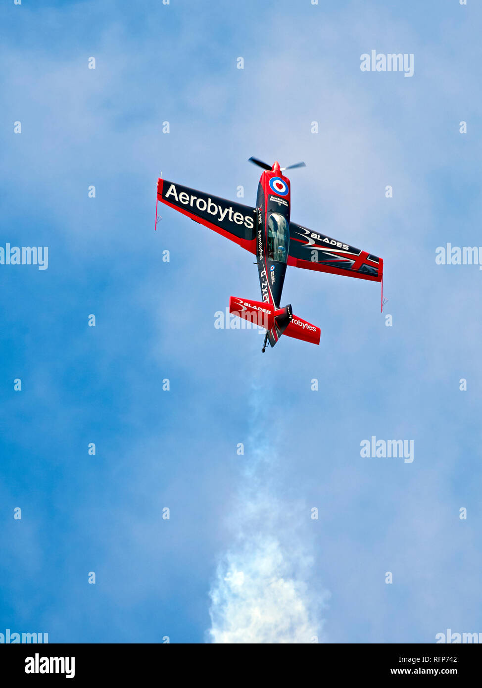 Una delle lame il display del Team Extra 300LS (finale del fumo bianco) si arrampica verticalmente in un cielo blu. Foto Stock