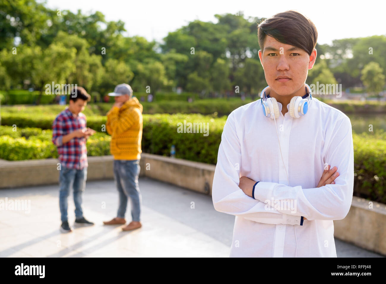 Tre giovani uomini asiatici di relax presso il parco insieme Foto Stock