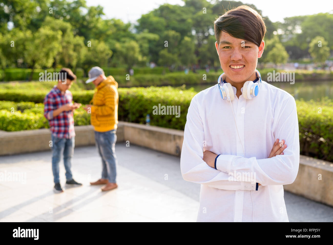 Tre giovani uomini asiatici di relax presso il parco insieme Foto Stock