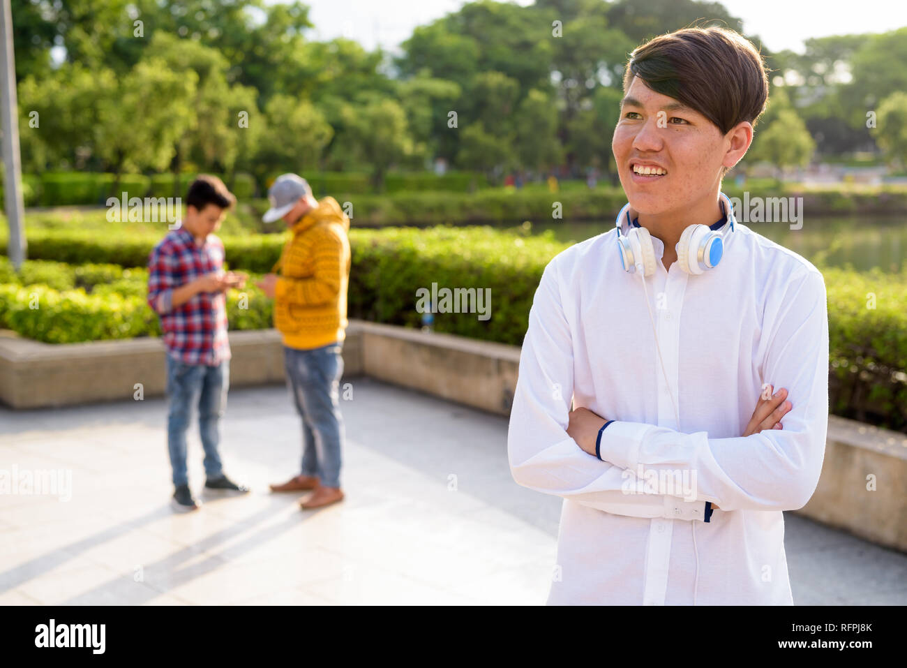 Tre giovani uomini asiatici di relax presso il parco insieme Foto Stock