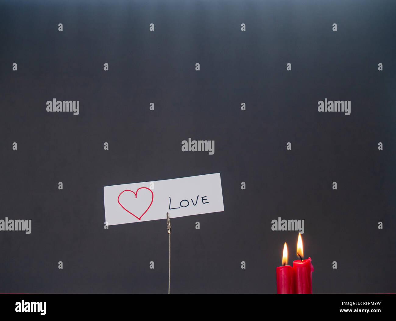Concetto di amore candele rosse accese e un cuore-supporto sagomato con il testo ti amo Foto Stock
