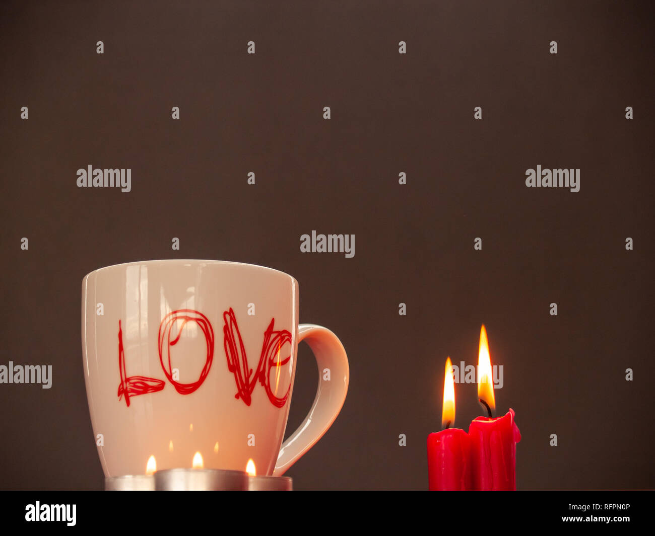 Concetto di amore ancora vita con rosso acceso candele e una colazione cup con la parola amore Foto Stock