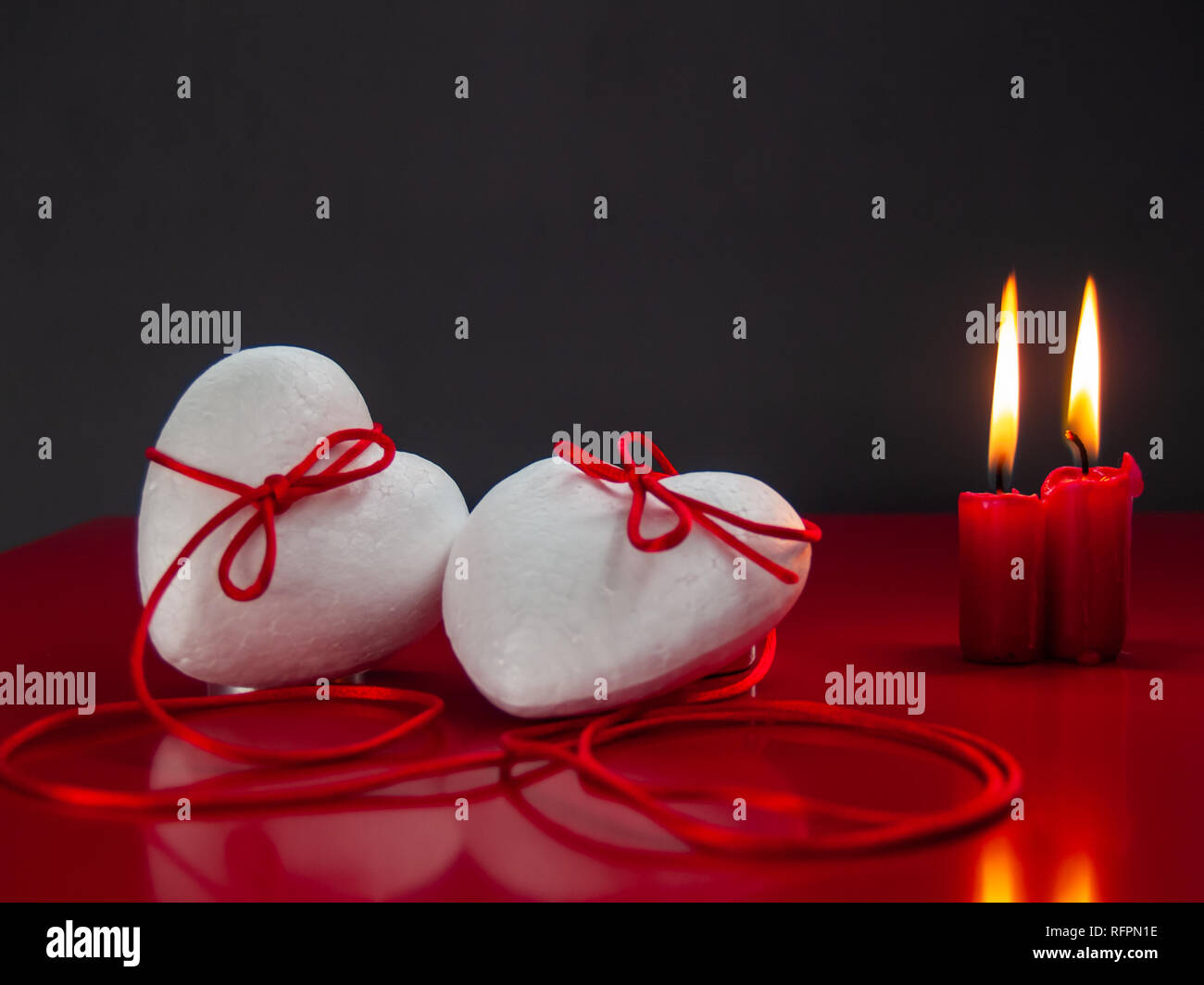 Concetto di amore poliespan due cuori uniti con un filo rosso che  simboleggia la leggenda del filo rosso e rosso due candele accese Foto  stock - Alamy
