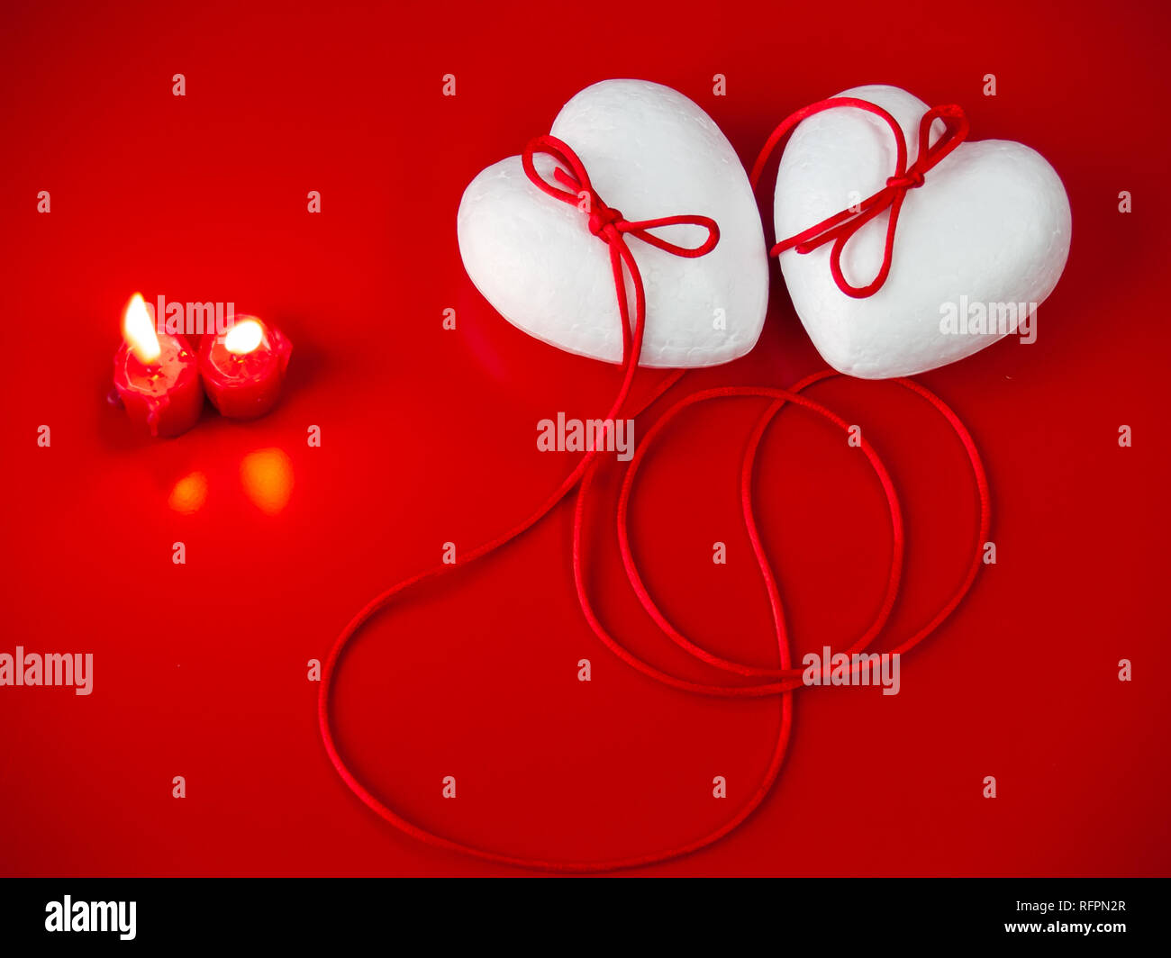Concetto di amore poliespan due cuori uniti con un filo rosso che  simboleggia la leggenda del filo rosso e rosso due candele accese Foto  stock - Alamy