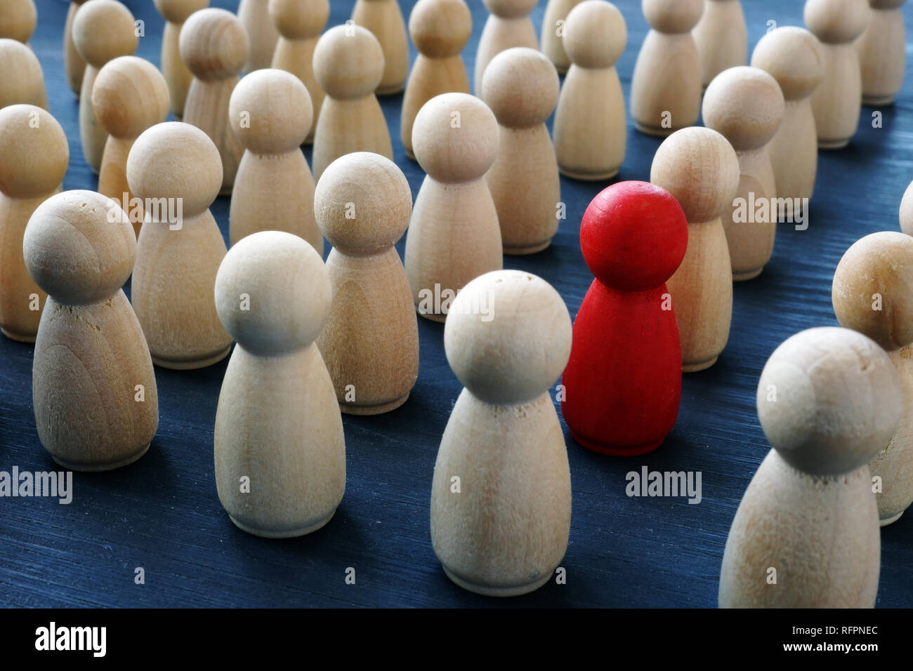 Unicità e individualità e differenza. In legno rosso figura in una folla. Foto Stock