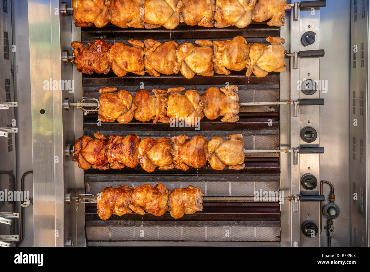 Essendo i polli arrosto allo spiedo sul lato di un furgone nel mercato spagnolo Foto Stock