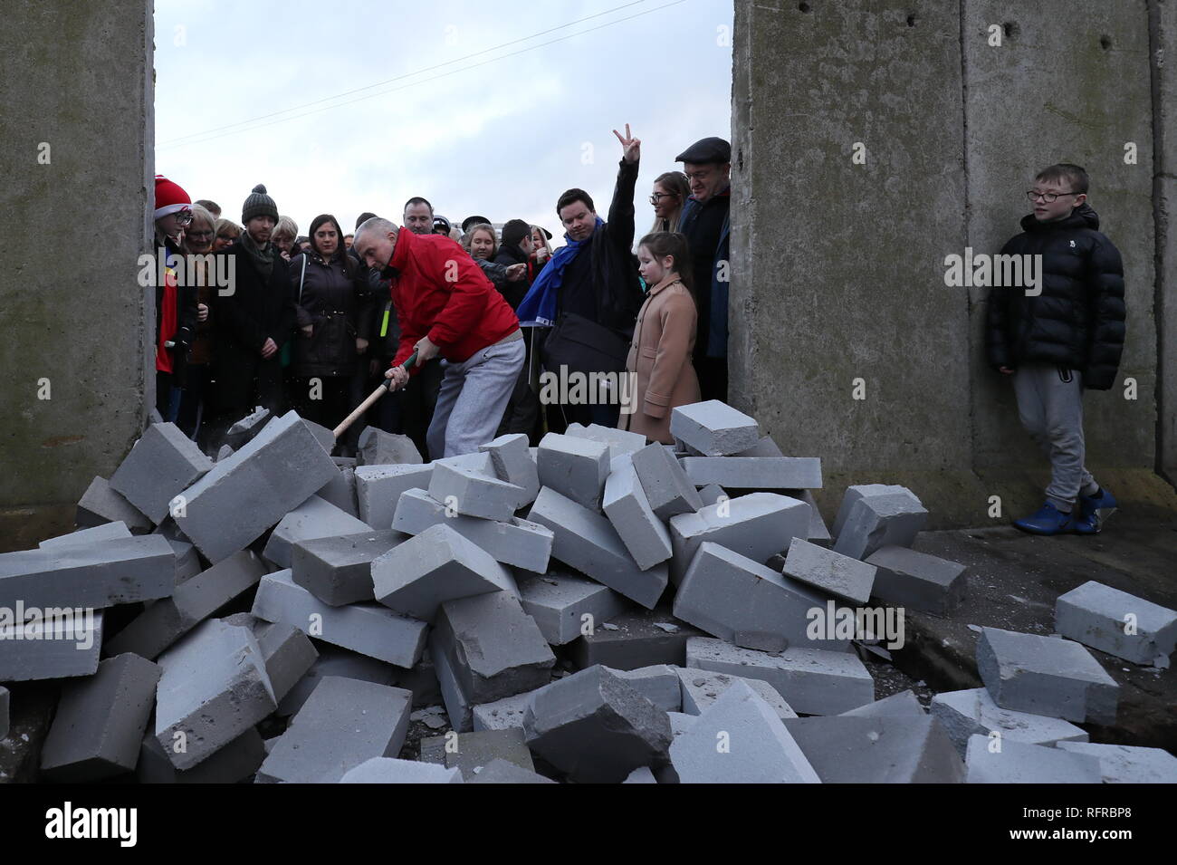 Manifestanti abbattere un muro simbolico che fu costruita come parte di un anti-Brexit al rally di frontiera irlandese vicino Carrickcarnan, Co Louth. Foto Stock