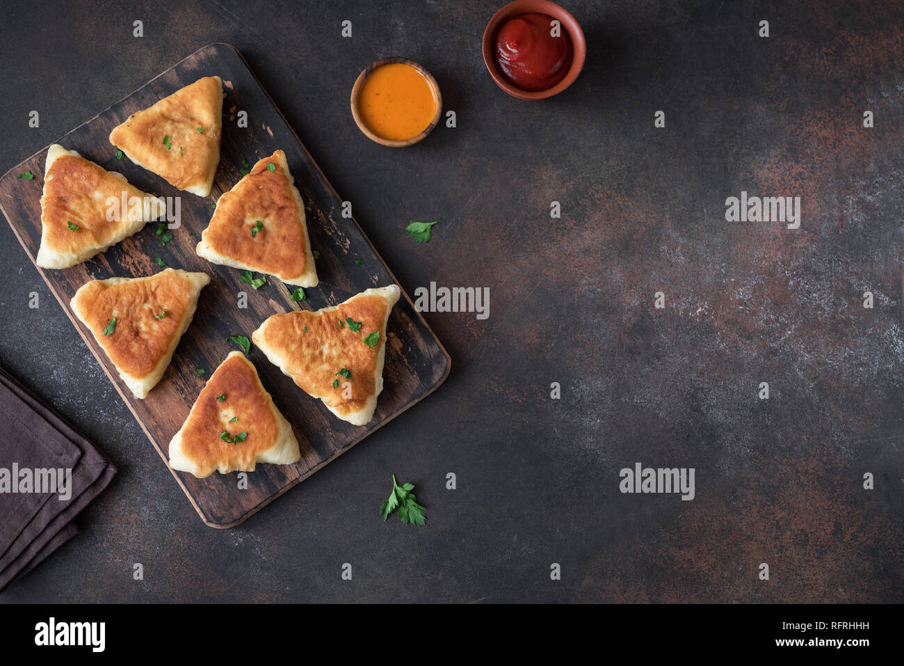 Fritte torte di verdure, samsa, samosas, echpochmak - Le carni tradizionali torte ripiene o torte vegetariane su sfondo rustico, copia dello spazio. Foto Stock