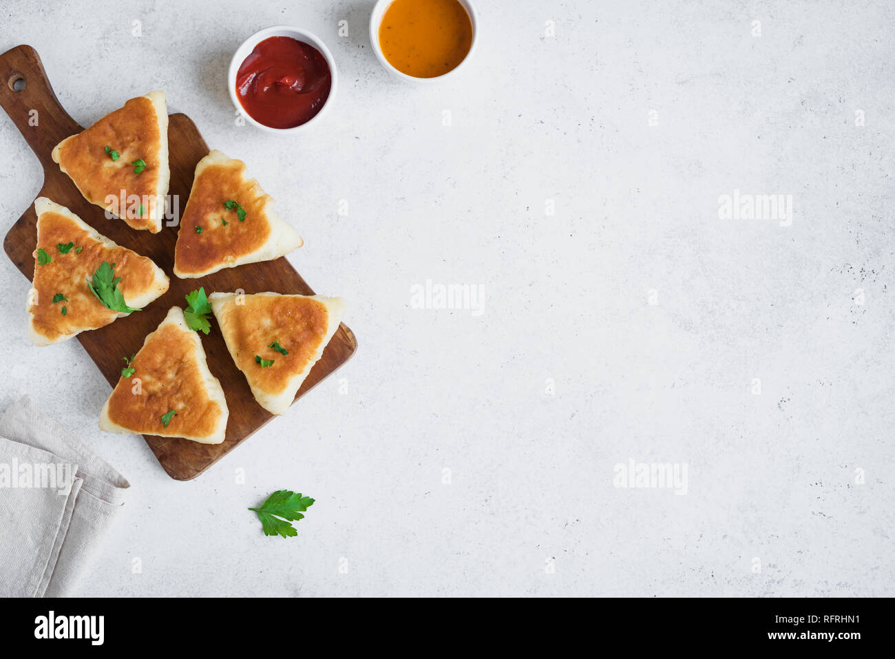 Fritte pasticci di carne con salse, samsa, samosas, echpochmak - Le carni tradizionali torte ripiene o torte vegetariane su sfondo bianco, copia dello spazio. Foto Stock