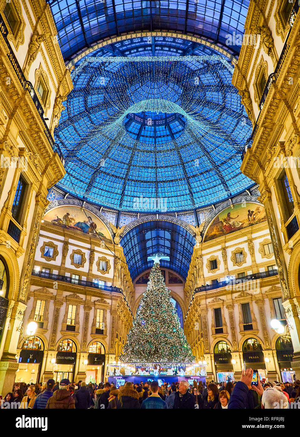 La gente che camminava sulla Galleria Vittorio Emanuele II illuminato da luci di Natale e un lucido albero di natale. Milano, lombardia, italia. Foto Stock