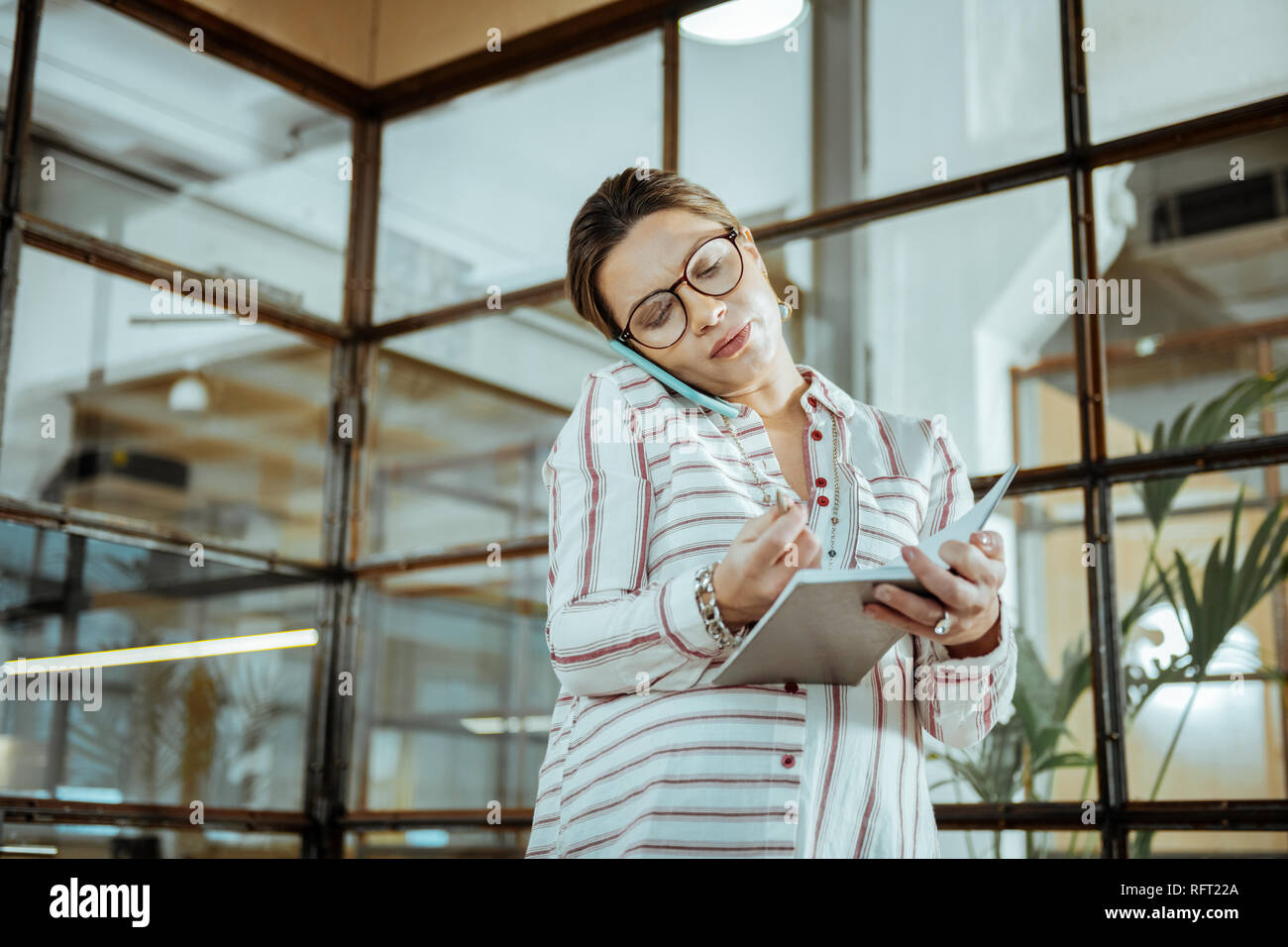 Incinta imprenditrice rendendo note dopo chiamata business Foto Stock