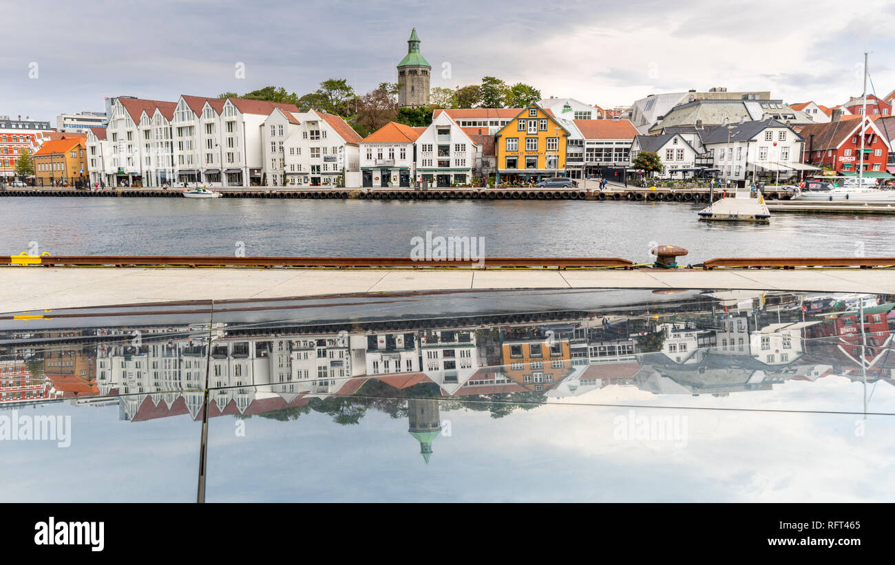 Porto di Stavanger con case storiche in background si riflette in una scultura in primo piano. Stavanger, Norvegia Foto Stock