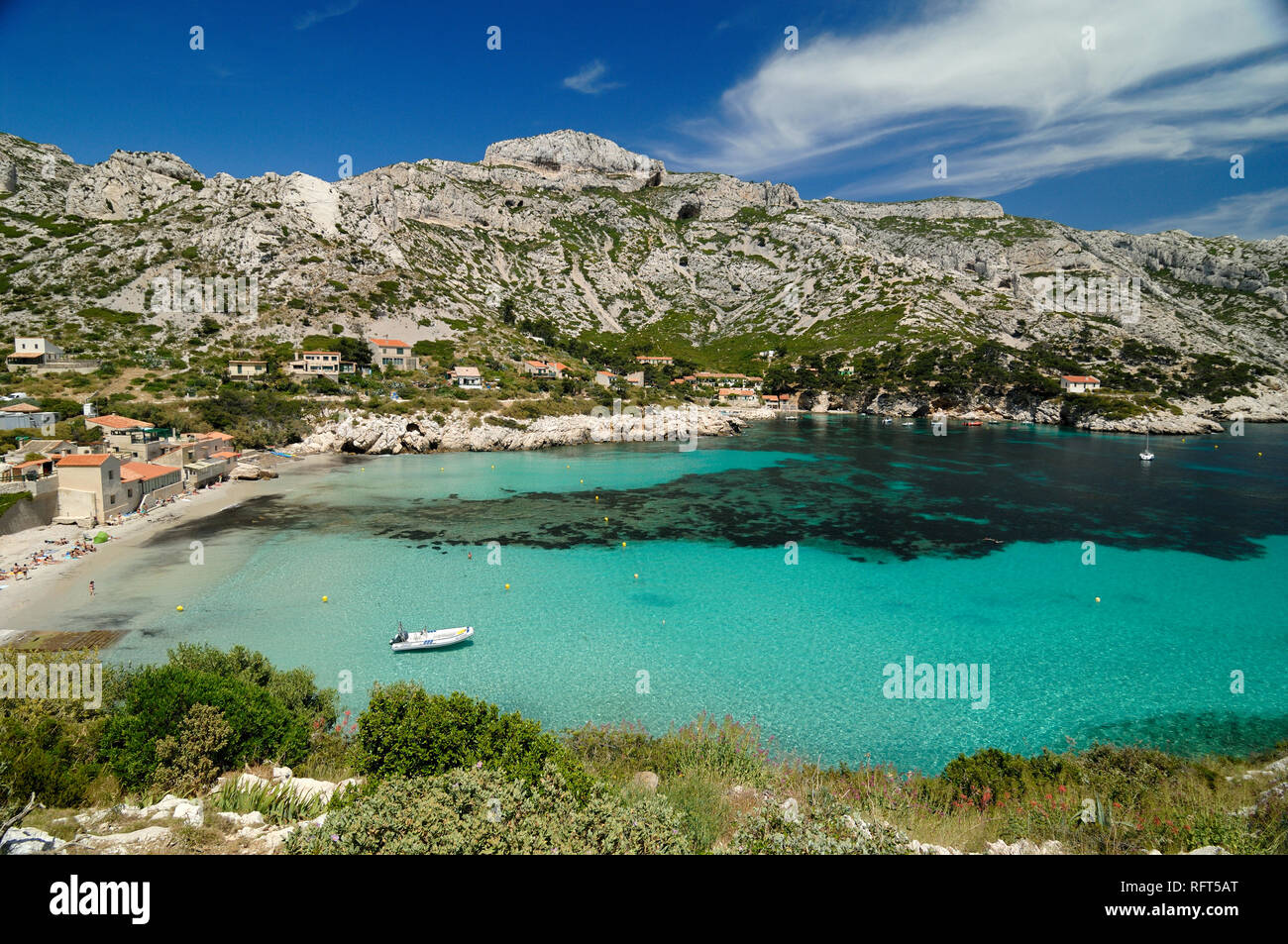 Piccola barca ormeggiata in acque blu turchese o fondali bassi di Sormiou Calanque nelle calanche Parco Nazionale o riserva naturale nei pressi di Marsiglia Provenza Foto Stock
