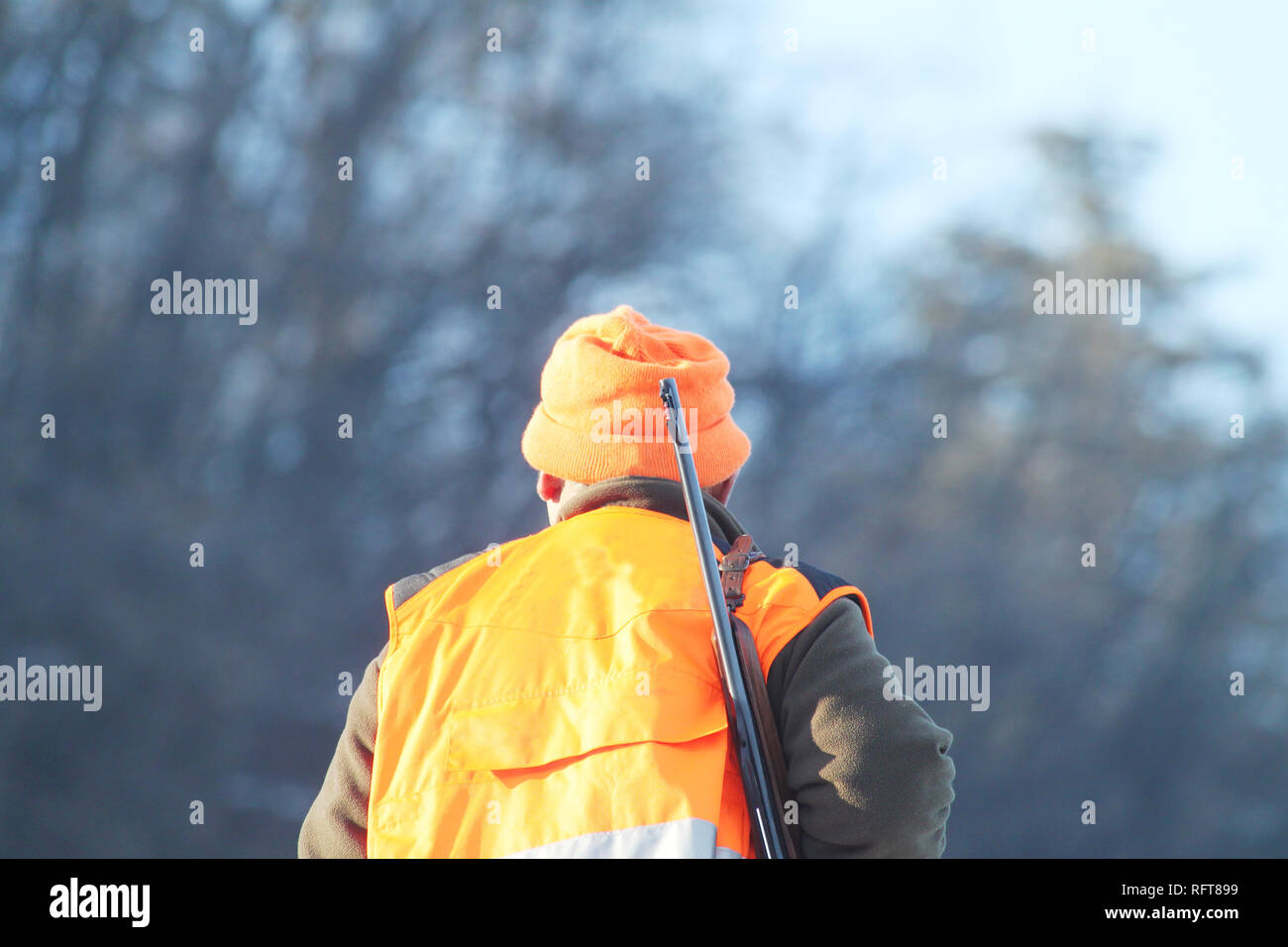 Cacciatore con alta visibilità abbigliamento e fucile, attesa per la caccia  al cinghiale nel paesaggio innevato. Concetto di suoneria Foto stock - Alamy