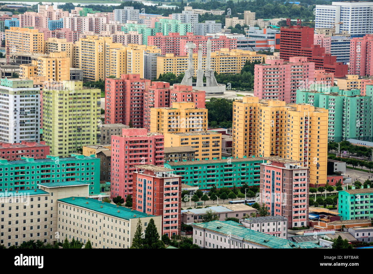 Partito dei lavoratori di un Monumento in mezzo dipinto di blocchi di appartamenti, visto da Juche Tower, Pyongyang, Corea del Nord, Asia Foto Stock