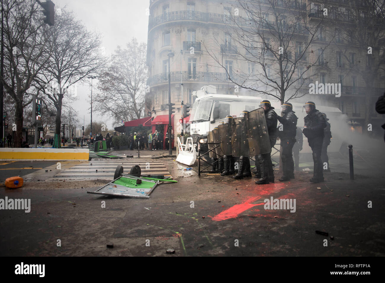La polizia antisommossa tenendo la loro posizione durante una dimostrazione contro macron politiche. Giubbotto giallo i manifestanti radunati e marzo per le strade di Parigi un altro sabato su ciò che essi chiamano la legge XI contro il presidente francese Emmanuel Macron politiche. Foto Stock