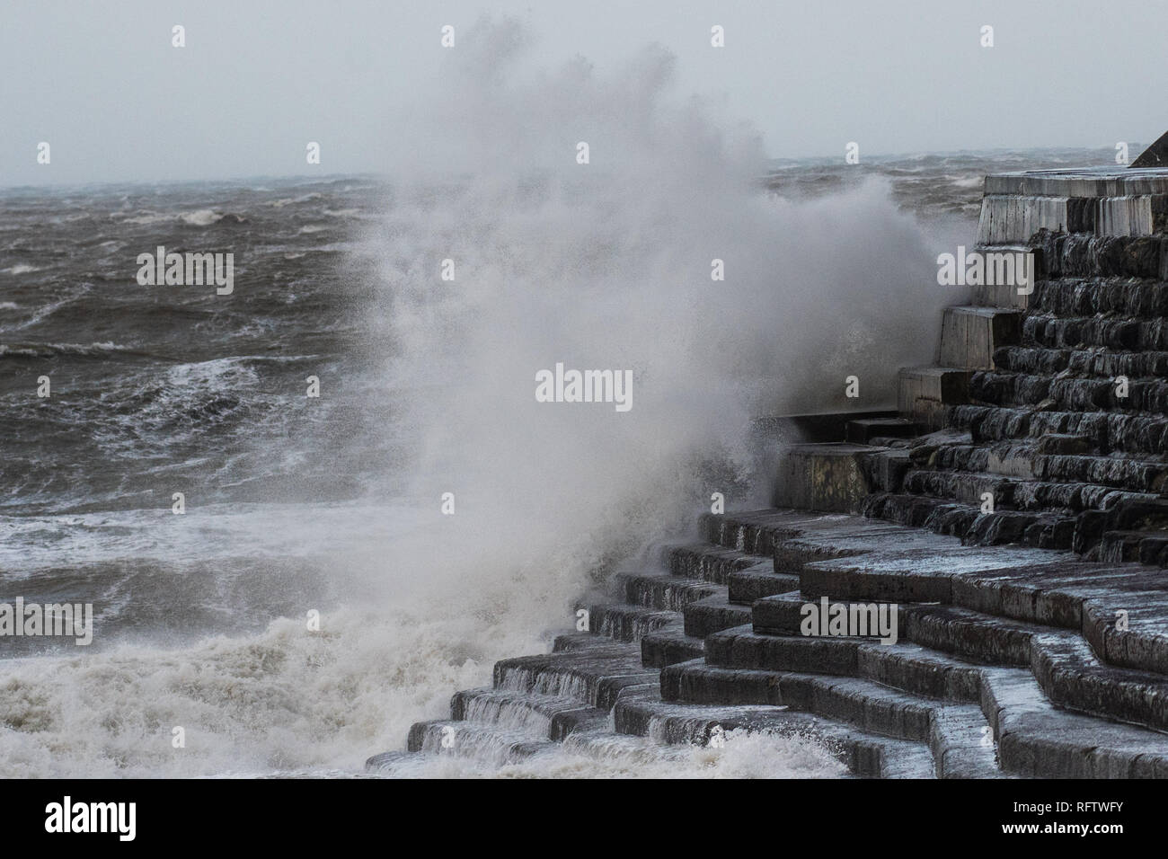 Aberystwyth Wales UK, domenica 27 Jan 2019. UK meteo: gale force, e terribilmente freddo, nord-ovest venti che soffiano fino a 70mph drive enormi onde nel mare difese a Aberystwyth in Galles occidentale. Un giallo Met Office di avvertimento alta venti è stato rilasciato che copre tutto il Galles e molto di wet DEL REGNO UNITO oggi. Photo credit Keith Morris / Alamy Live News Foto Stock
