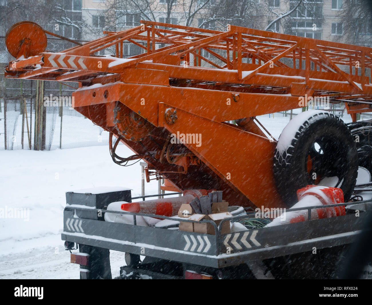 Città utility di riparazione di gru da cantiere con orange coni stradali a stagione invernale Foto Stock