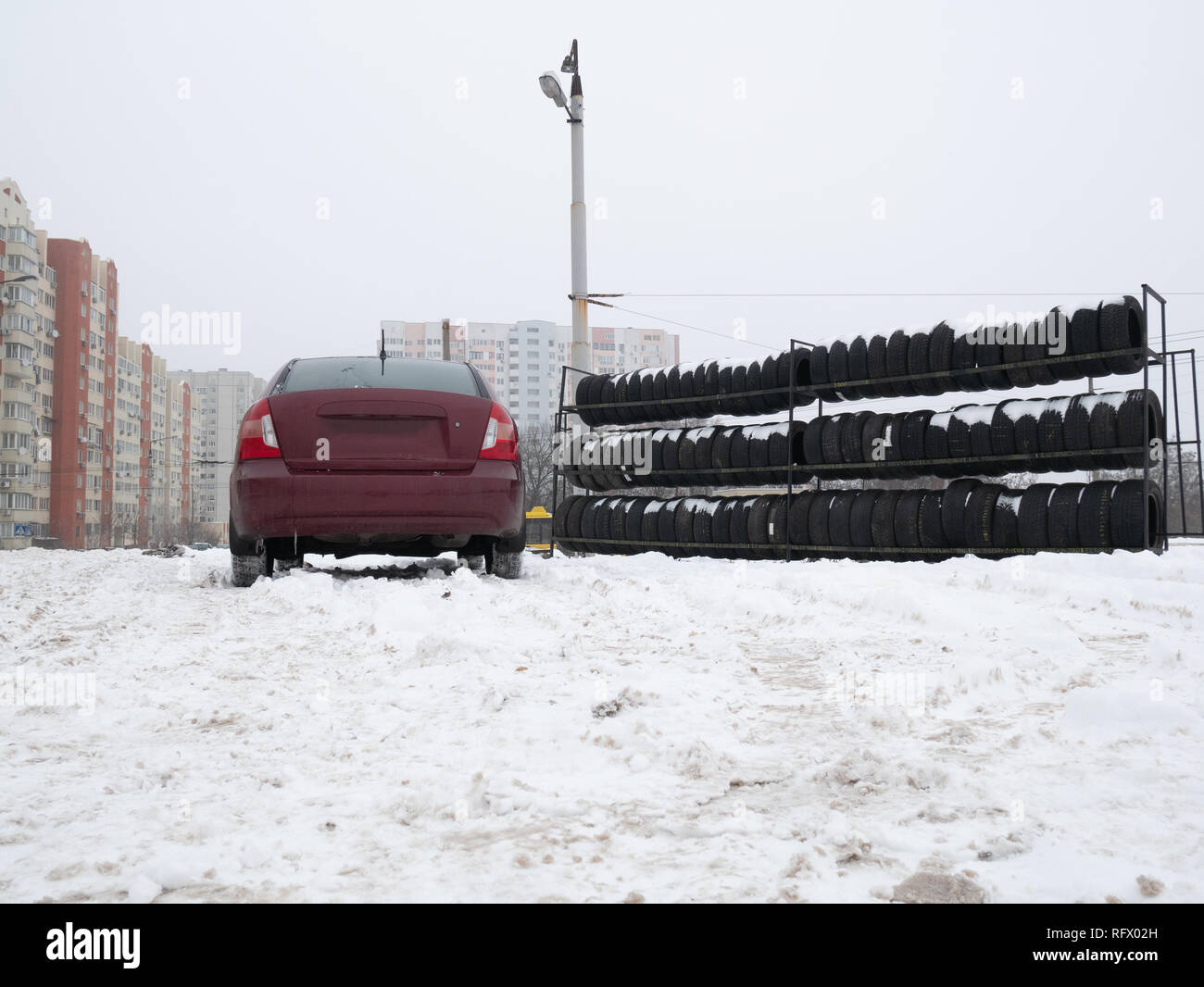 Auto in piedi vicino a Tires store. stagionale cambiare pneumatico concept. superficie di livello basso angolo outdoor inverno immagine Foto Stock