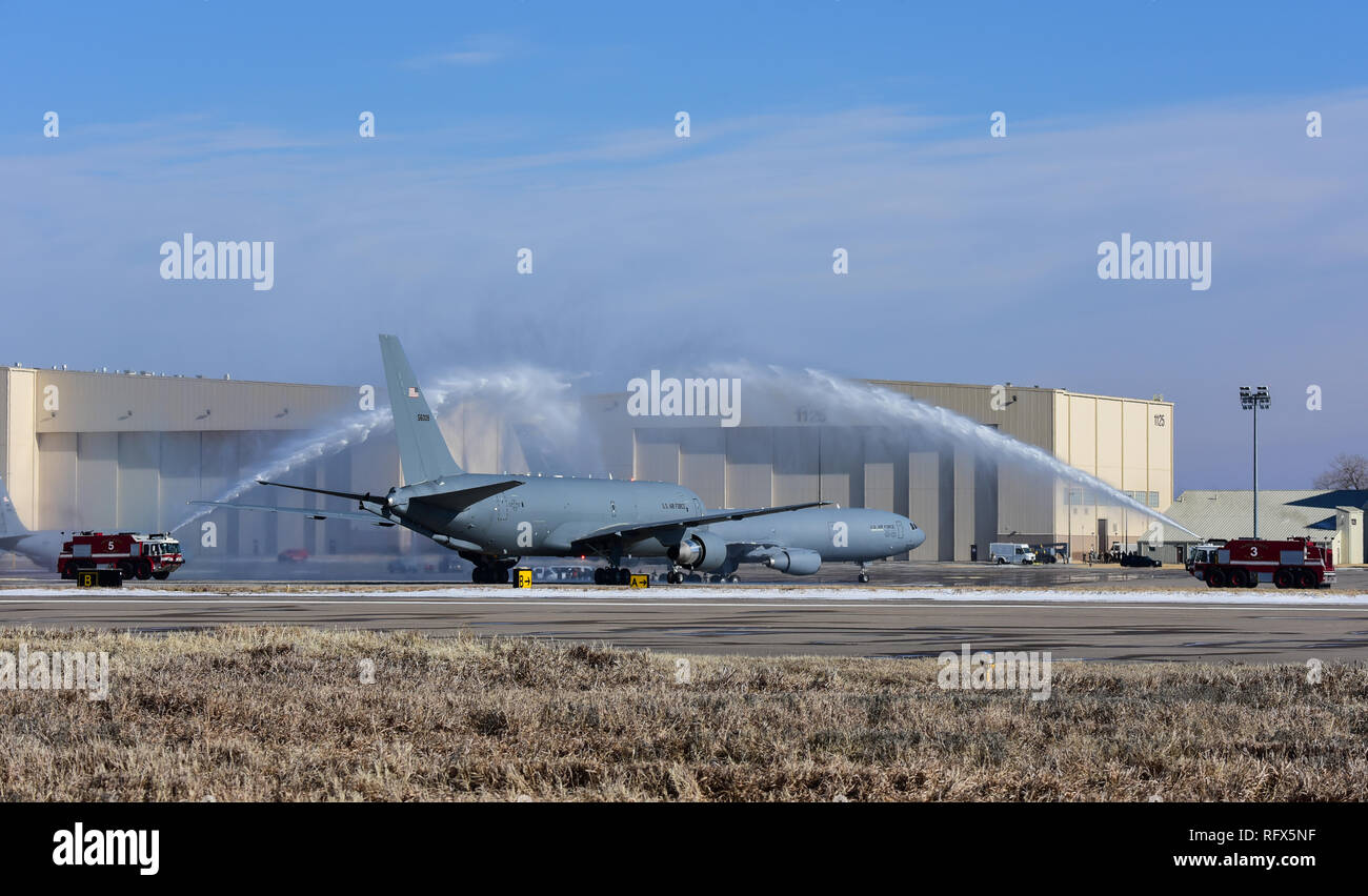Camion fuoco assegnato alla ventiduesima ingegnere civile Squadron eseguire un acqua-salute mentre il primo KC-46A Pegasus i taxi all'Hangar 1126 Gen 25, 2019, a McConnell Air Force Base, Kan. I manutentori trainato il velivolo per la parte anteriore di un hangar per essere presentato durante il KC-46 Cerimonia di arrivo. (U.S. Air Force foto di Airman 1. Classe Alan Ricker) Foto Stock