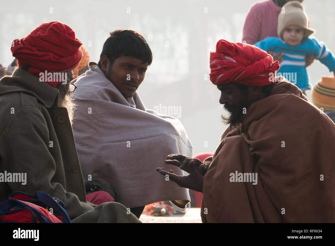 Uomini spirituali seduto al fiume Gange a freddo in inverno mattina in Haridwar, Uttarakhand, India Foto Stock