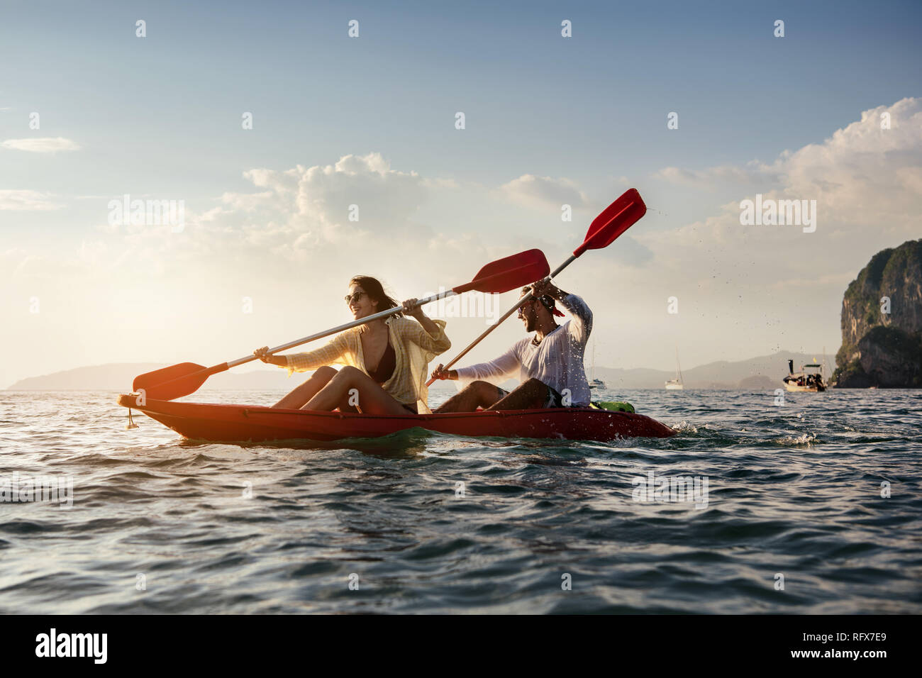Coppia felice passeggiate in mare kayak o canoa al tramonto bay. In kayak o canoa concetto con persone Foto Stock