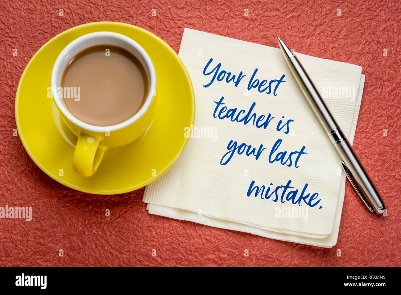 Il tuo insegnante migliore è il tuo ultimo errore - scrittura su un tovagliolo con una tazza di caffè Foto Stock