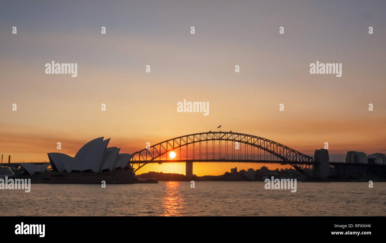 Un colpo di sole che tramonta dietro alla Opera House di Sydney Foto Stock