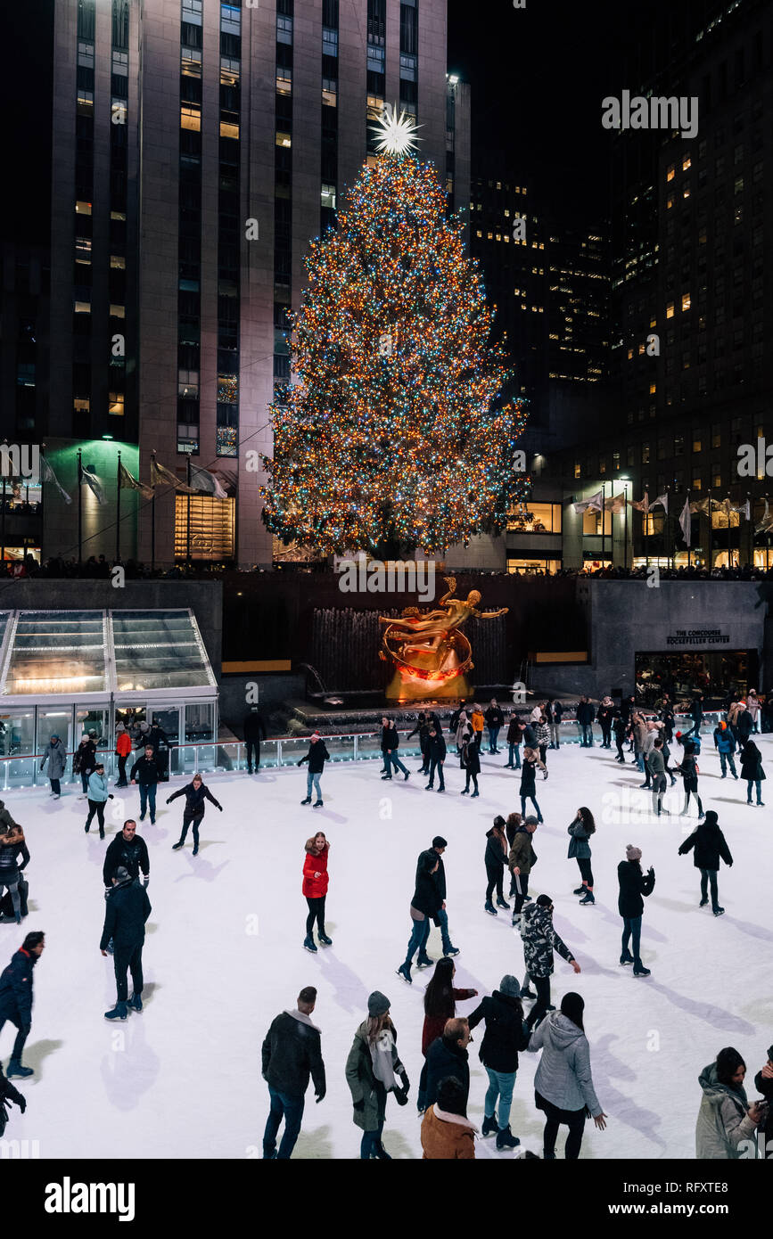 Albero di natale e la pista di pattinaggio su ghiaccio al Rockefeller Center di notte in Midtown Manhattan, a New York City Foto Stock