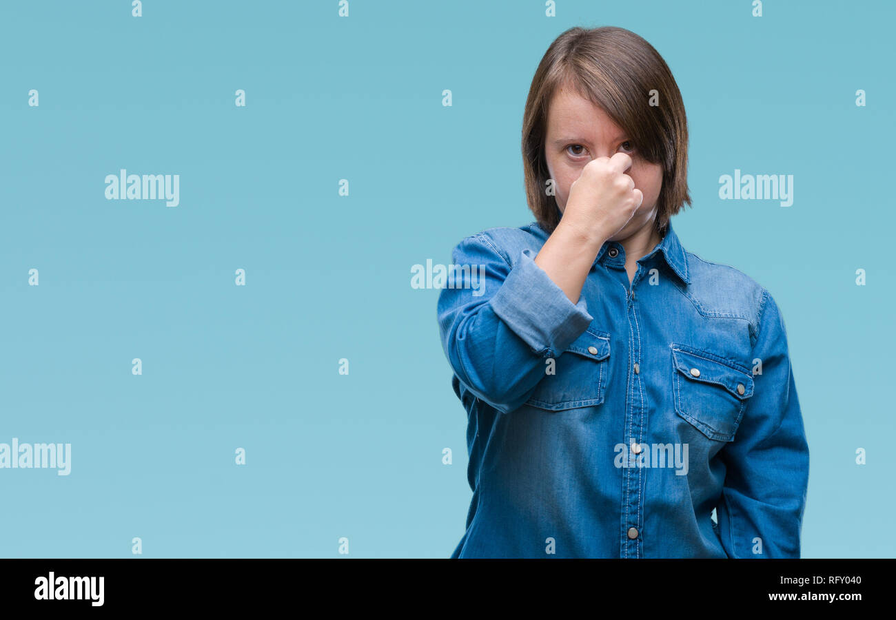 Giovane donna adulta con la sindrome di down su sfondo isolato stanco strofinando il naso e gli occhi sensazione di stanchezza e mal di testa. Stress e frustrazione concept Foto Stock