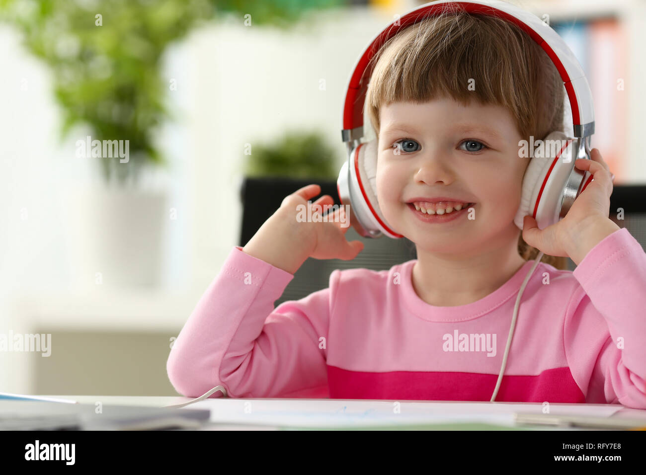 Bambino soddisfatto nella seduta delle cuffie Foto Stock
