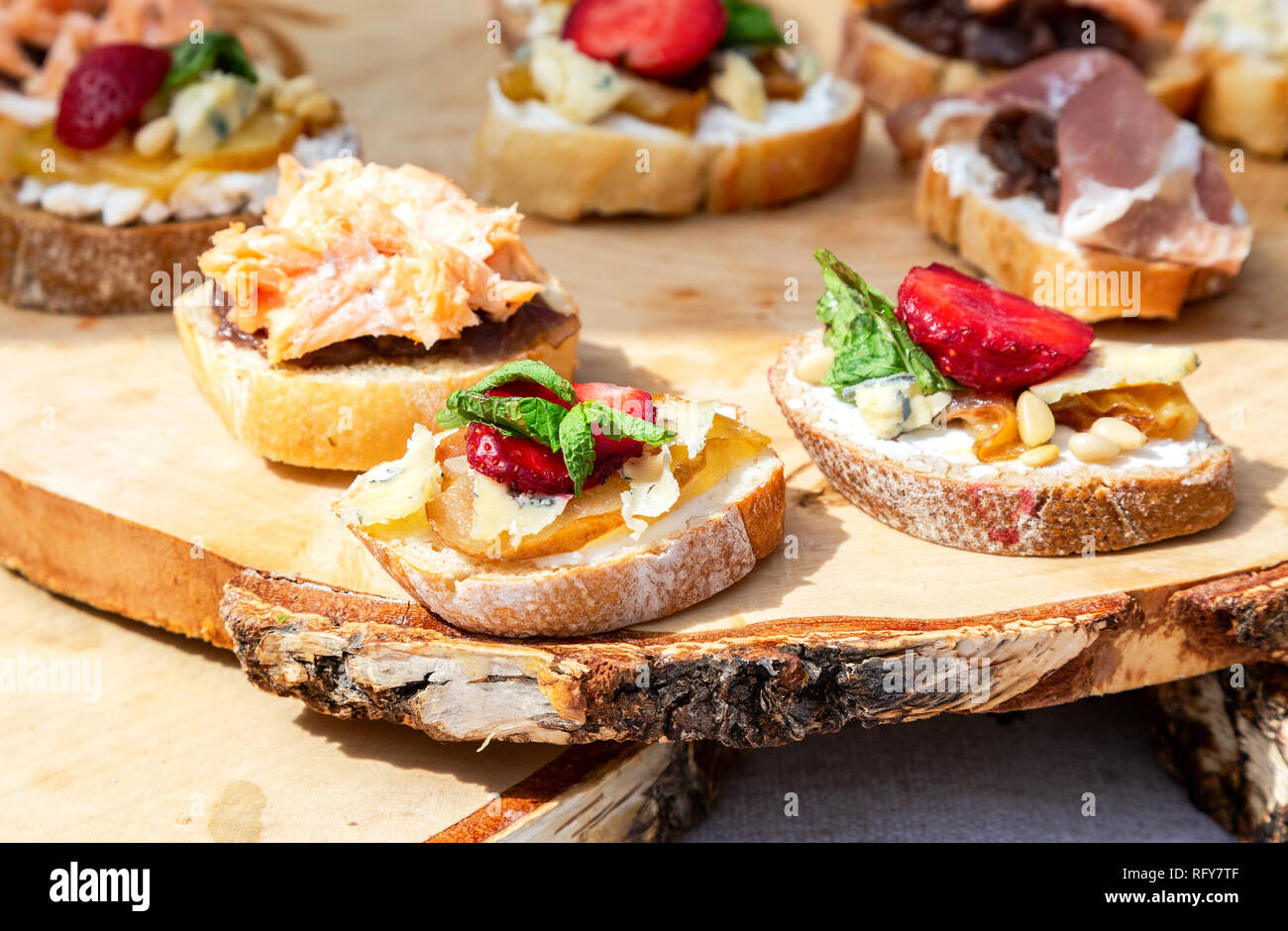 Gustosi panini freschi con differente riempimento sulla tavola di legno Foto Stock
