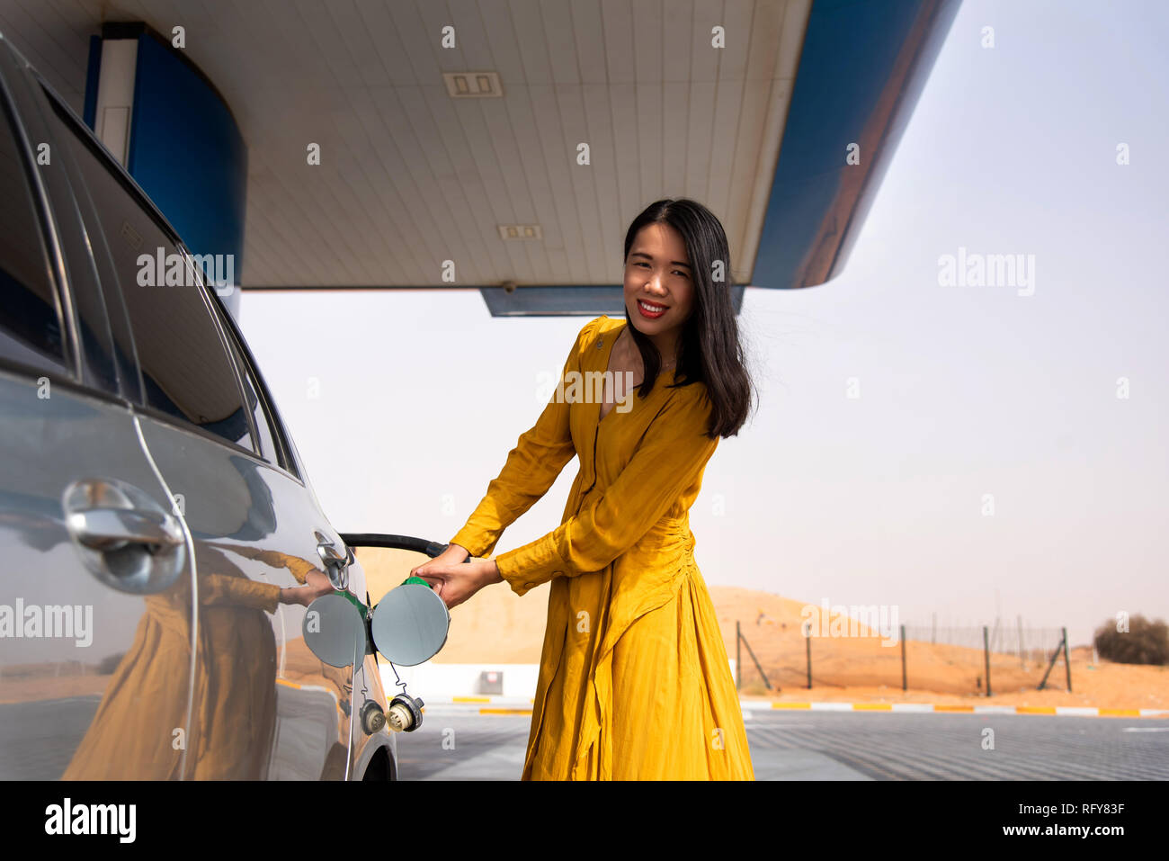 Donna aggiungendo benzina sulla stazione di benzina da soli Foto Stock
