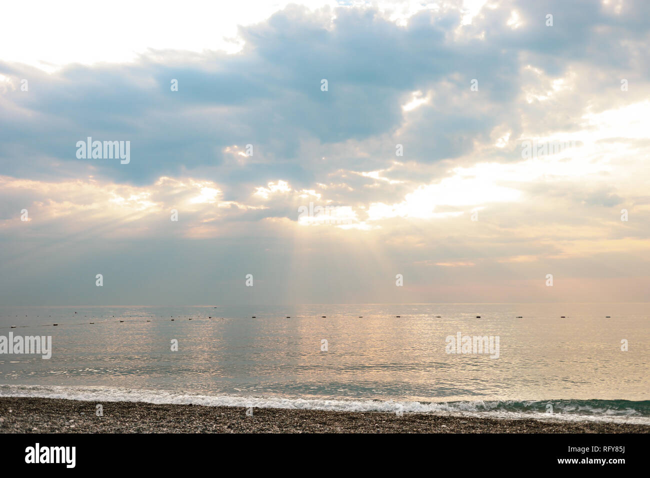 Vista del cielo meraviglioso con maestose nuvole e raggi di sole e di mare. Seascape su alba. Foto Stock