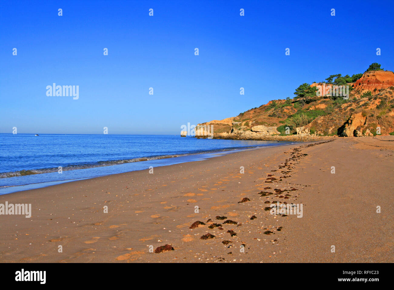 Refrigerazione e a piedi a una bella spiaggia chiamata Praia da Falesia in Portogallo. Sunrise sulla solitudine spiaggia tranquilla è così rilassante. Foto Stock