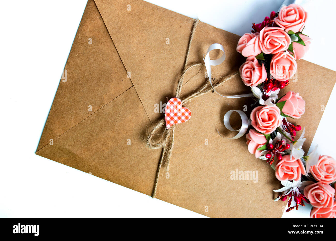 Busta da lettera e fiori su bianco isolato Foto Stock