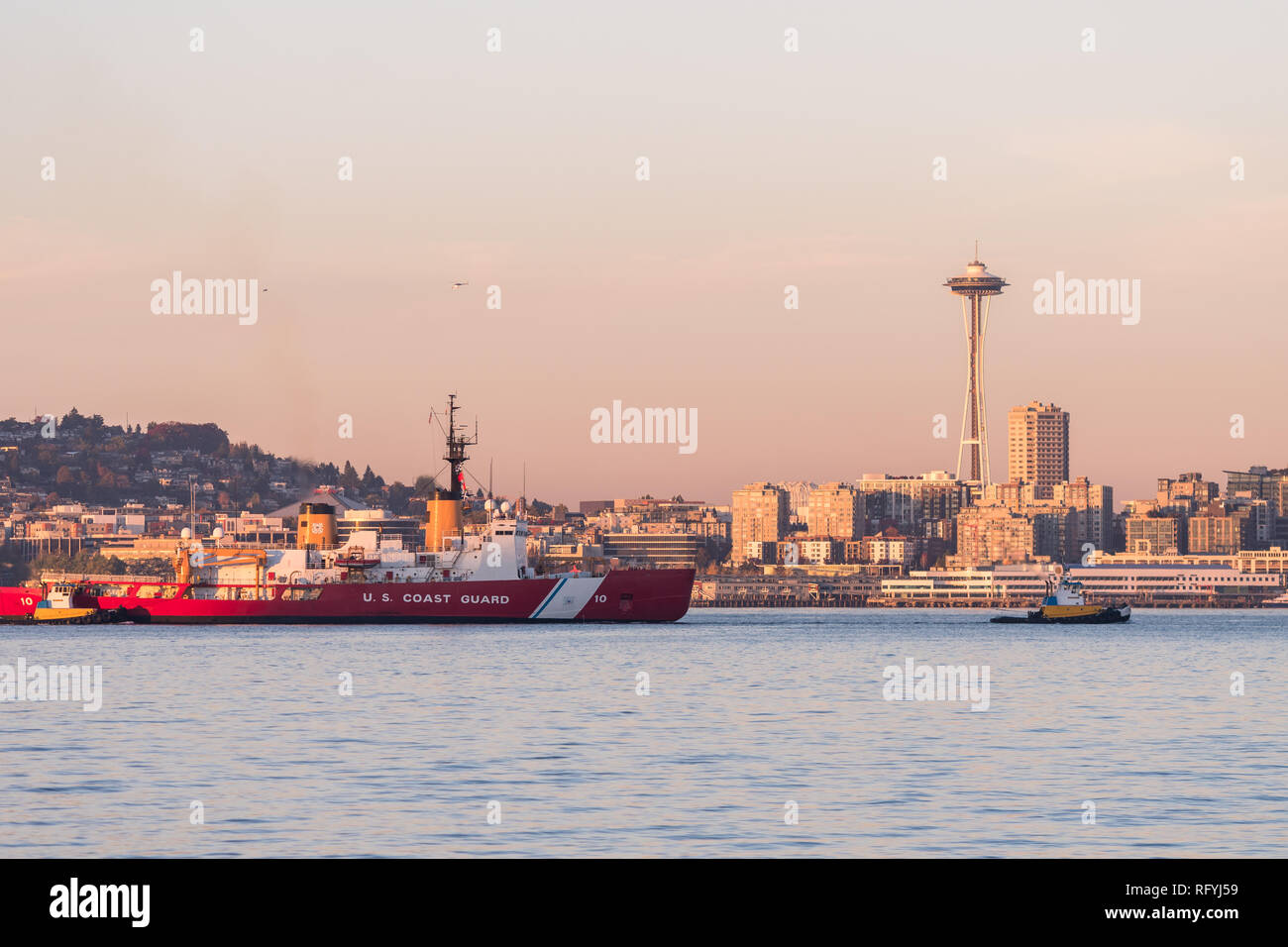 La guardia costiera in barca della Baia di Elliott con tramonto sui grattacieli del centro di Seattle, Washington, Stati Uniti d'America. Foto Stock