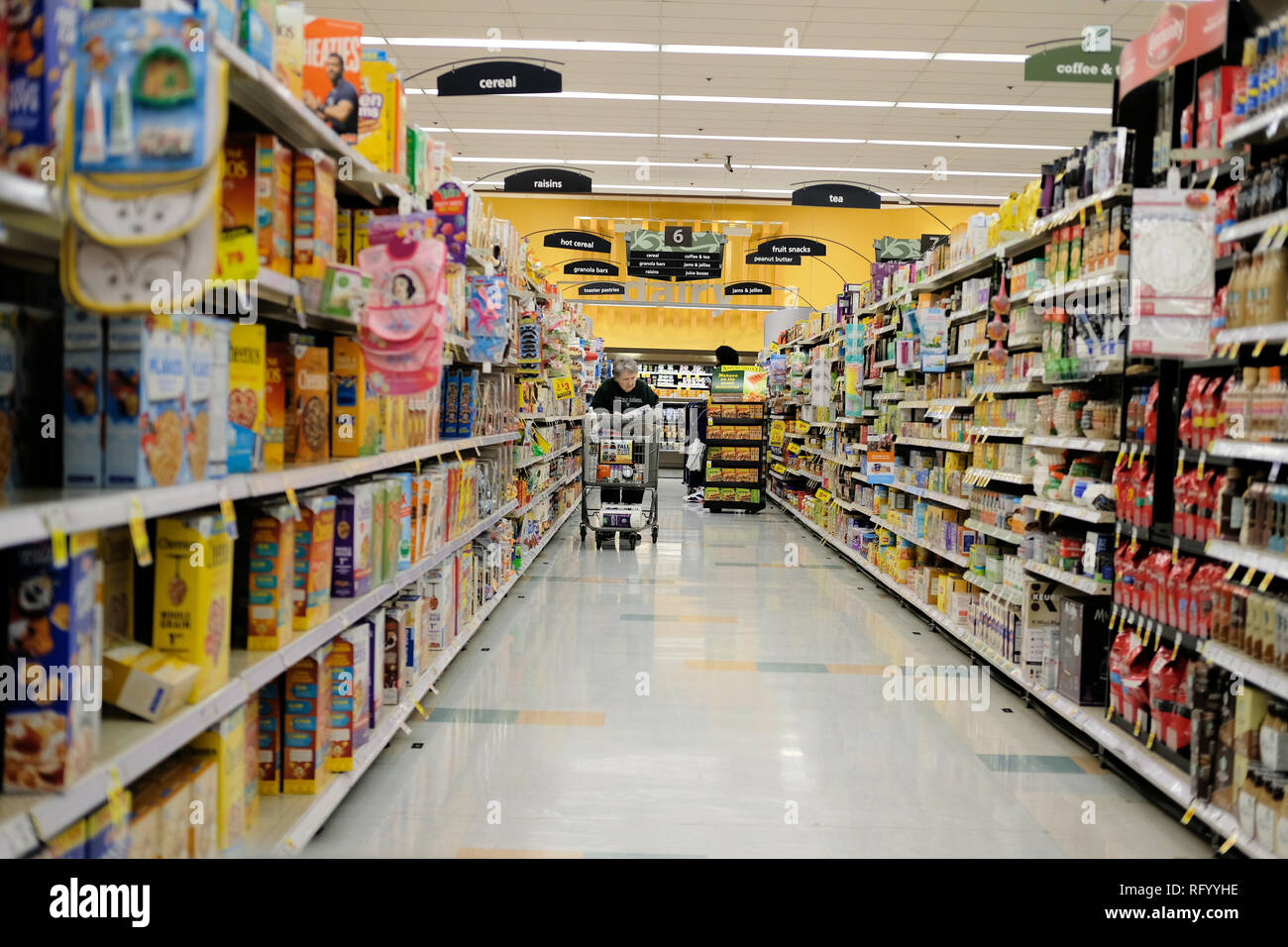 Negozio di alimentari corsia con shopper e shopping cart. Foto Stock
